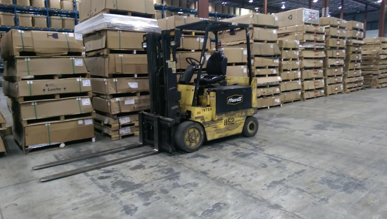 Forklift moving palletized freight in KDM's warehouse